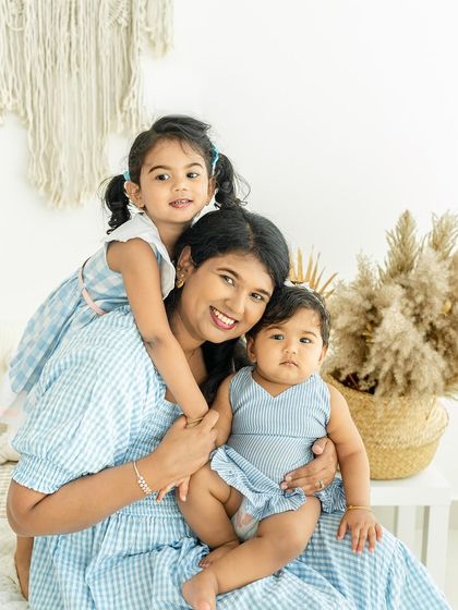 A mother surrounded by her two lovely daughters. This shot is filled with love and affection, from the piggyback hug to the gentle hold of the baby.