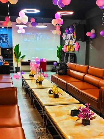 A wide view of the party setup for Amyra, showing how the balloons on the ceiling and the main backdrop decorate the entire room.