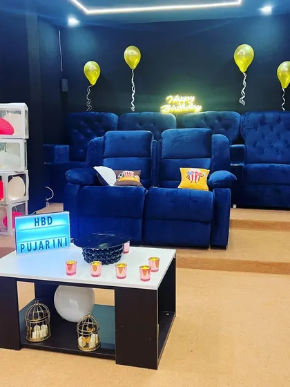 This is your private cinema. Plush blue recliners, a giant screen, and a personalized setup ready for your celebration. This view shows the simple elegance of our space before the party starts, a blank canvas for your birthday, anniversary, or movie night.