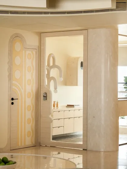 A view of the living area in the 'Soft Serve' apartment, showing the custom-painted door with geometric patterns and the sculptural ceiling. The design is based on 'Seijaku,' a Japanese concept of tranquility in the midst of a bustling city.