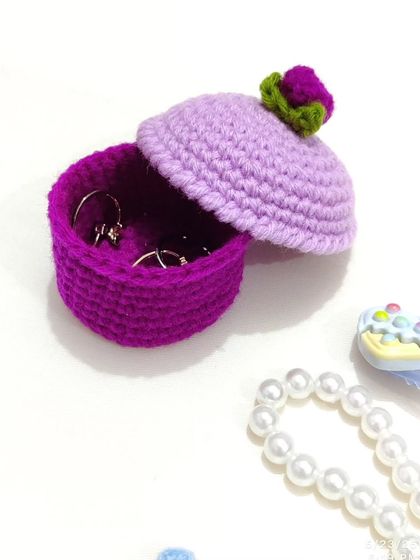 The cupcake ring box with the lid half-open, showing rings inside.