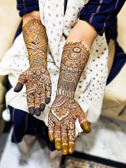 A full view of an intricate bridal design, showing the different patterns on each hand.