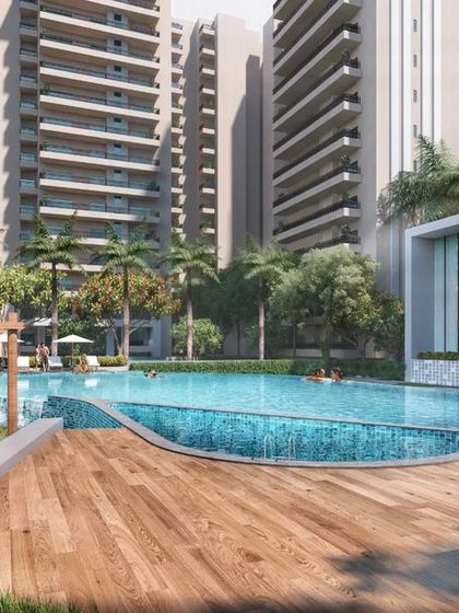 A view of the swimming pool and wooden deck at the 'Oasis Grand Stand' housing project. The design includes shaded pergolas and comfortable lounge areas, creating a resort-style amenity for residents.