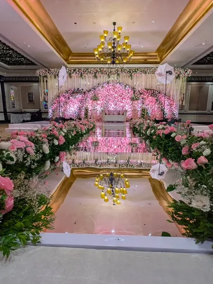 To create a truly romantic and grand reception, I designed this magnificent stage with an aisle of mirrors. The reflective surface beautifully duplicates the thousands of pink roses on the backdrop, amplifying the floral fantasy and creating an endless path of blooms.