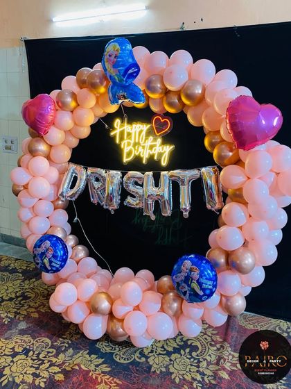 A complete view of the Frozen-themed ring decoration, showing the placement of the character and heart-shaped foil balloons on the circular arch.