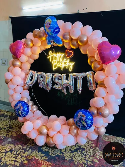 A complete view of the Frozen-themed ring decoration, showing the placement of the character and heart-shaped foil balloons on the circular arch.