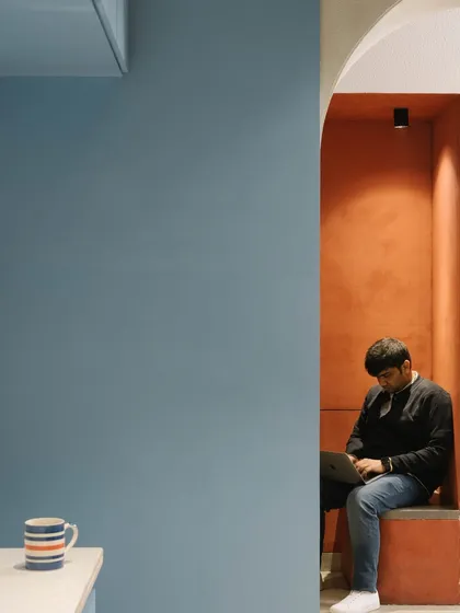 A staff member utilizes one of the informal working nooks built into the corridor. These spaces provide alternative work environments to the traditional desk.