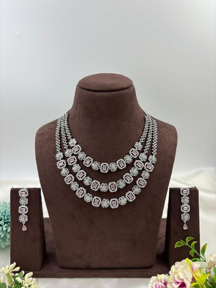A three-row AD necklace set with square-cut stones. This classic and elegant design is available in all-white, mint green, ruby, blue, and a multi-color option.