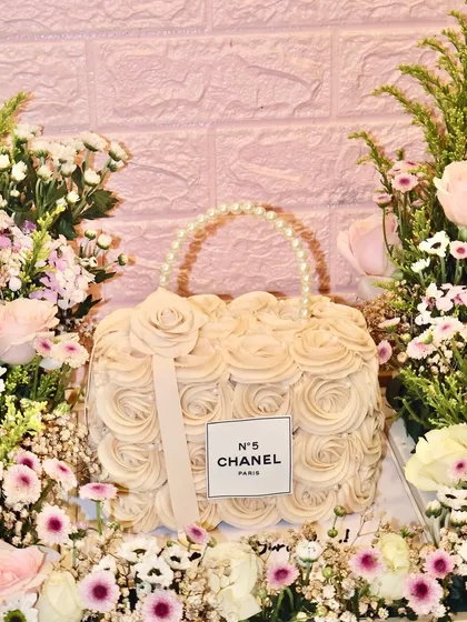 A little Coco and a little couture. Our Chanel bag cake, surrounded by a bed of fresh flowers, is the ultimate luxury centerpiece.