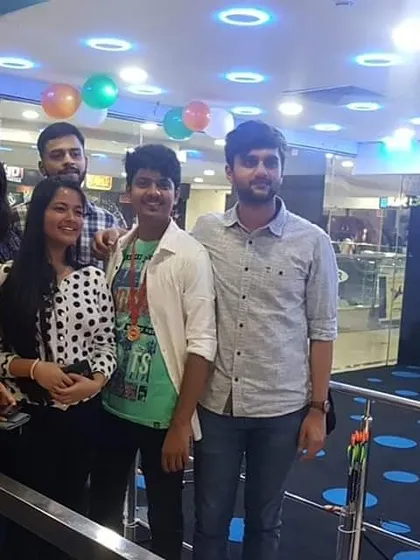 An awesome group of friends posing for a photo. One of them proudly wears a medal, showing their success from the day's activity.