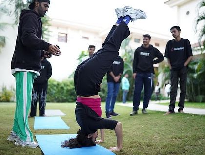 A participant at our Polkadot corporate event nails a headstand. We love helping teams step out of their comfort zones and achieve things they didn't think were possible.