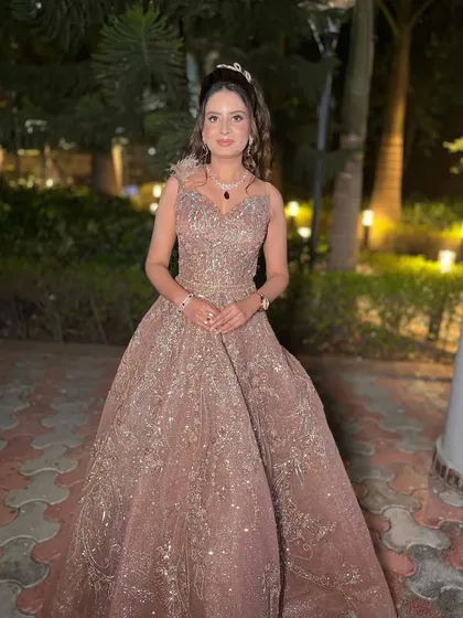 This bride is living her fairytale moment. Her shimmering gown is paired with a soft, glossy makeup look and a romantic half-up hairstyle, perfect for an engagement party.