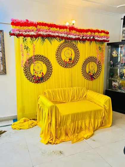 This image shows the full view of the home function backdrop. The top is lined with rows of fresh flowers, and hanging floral strings are added on the sides for a complete look.