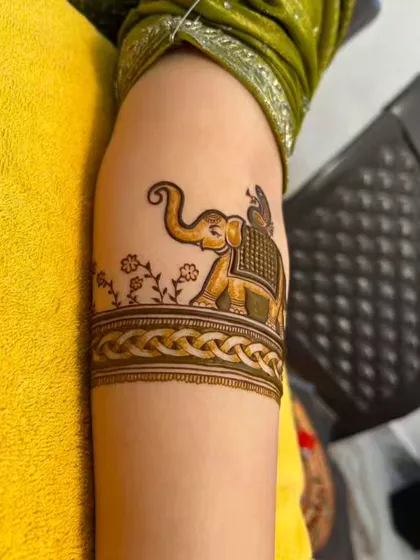 A simple yet elegant elephant motif on the upper arm. This is a great option for someone who wants a touch of figurative art without a full bridal design.