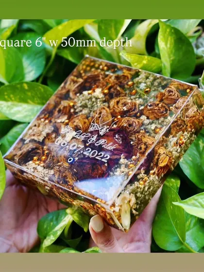 A square 6-inch resin block with a 50mm depth, filled with preserved brown-toned roses and golden accents. The couple's names and wedding date are elegantly engraved on the surface.