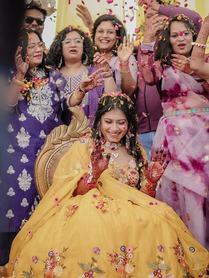 The bride is showered with flower petals by her family during her mehendi ceremony, a moment of pure celebration.