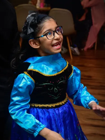 A happy party guest dressed as Princess Anna from "Frozen."