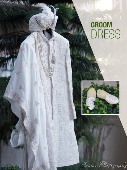 A detail shot of the groom's elegant white sherwani, turban, and matching shoes.
