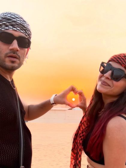 Making a heart with the sunset during our desert safari in Dubai. The traditional headscarves added an authentic touch to our desert outfits.