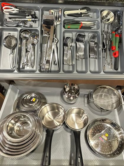 A comprehensive look at a utensil and cookware drawer system. The top drawer holds all the cutlery, while the bottom is for steel pots, pans, and serving bowls.