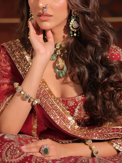 A detailed shot focusing on the exquisite craftsmanship of the blouse and the layered jewellery. Every element is chosen to complement the others perfectly.