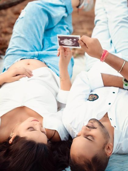 A relaxed and intimate moment, lying on a blanket and looking at the ultrasound photo together. This is a beautiful memory of your journey.