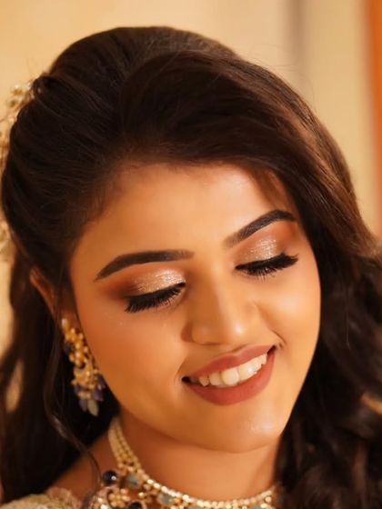 The smile says it all. This reception look, with its warm gold glittery eyes and perfectly matched lip color, is designed to last through a night of dancing and celebration.