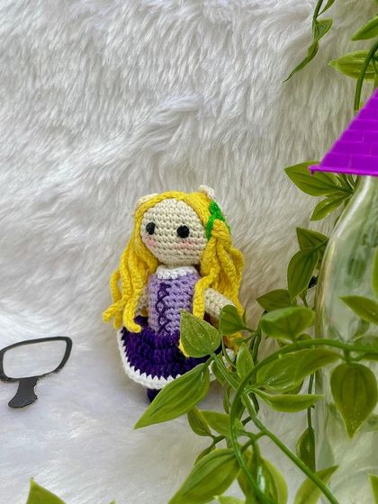 Disney Princess Rapunzel, with her long, flowing yellow hair decorated with flowers. Her purple dress is detailed with corset lacing, just like in the movie Tangled.