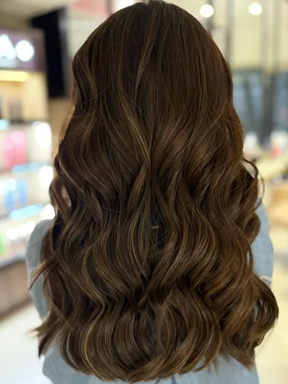 A classic highlight blend for a fresh, summer-ready look. The client's smile shows how happy she is with her new hair.