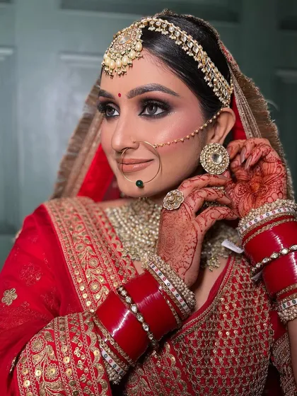 A timeless moment captured. This is the classic Indian bride, radiant and poised. My focus here was on creating flawless skin and sharp, expressive eyes that complement her stunning red lehenga and polki jewellery.