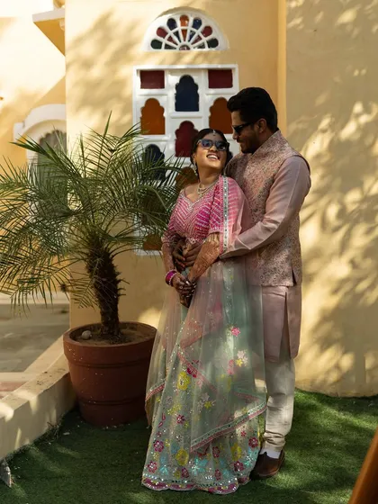 The couple shares a happy moment during their pastel Haldi ceremony. Their coordinated outfits perfectly match the yellow and lavender theme we designed.