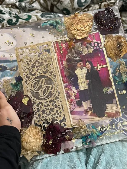 A unique keepsake preserving a laser-cut wedding invitation alongside a photo and flowers. It’s a beautiful way to combine different elements from your wedding.