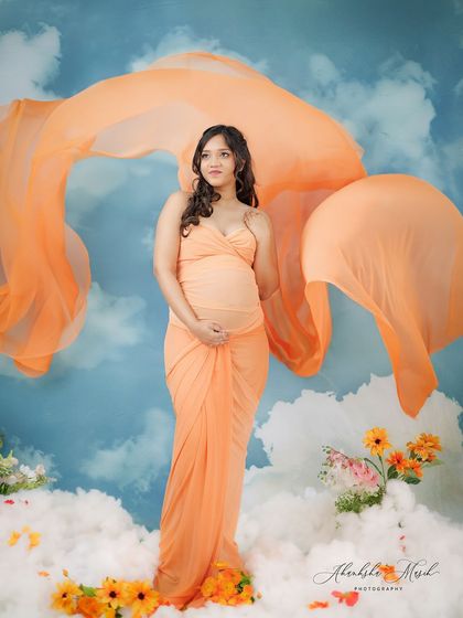 The flowing orange fabric seems to dance in the wind in this dreamy cloudscape portrait, adding a beautiful sense of movement and freedom.