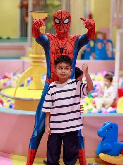 The birthday boy gives a thumbs-up next to his hero, Spider-Man, in our colorful ball pit area. It's a perfect photo that captures the excitement of the day.