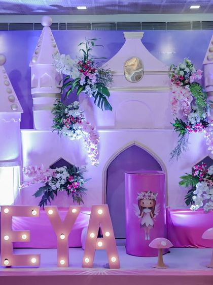 The centerpiece of the Fairy Wonderland party: a beautiful castle backdrop adorned with flowers and flanked by marquee letters and whimsical props.