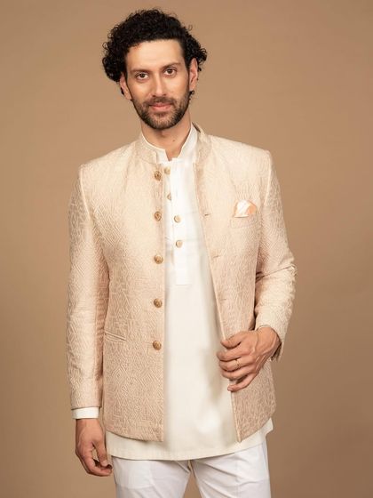 Ready to turn heads. This embroidered bandhgala in a soft peach hue is perfect for any traditional occasion. The subtle texture and classic tailoring create a look of refined elegance.