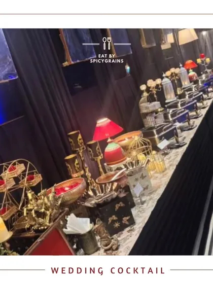 A beautifully arranged buffet for a wedding cocktail party. The setup features elegant decor with red accents and a variety of dishes to suit every palate.