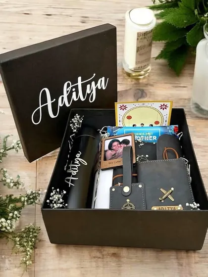 This personalized Rakhi gift box for 'Aditya' is one of my most popular designs, featuring a custom-named tumbler, wallet, keychain, and a photo frame, all presented in a sleek black box with his name on the lid.