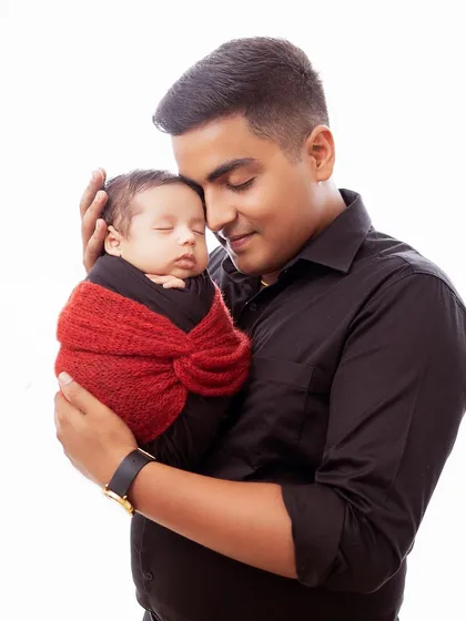 A simple and powerful portrait of a father holding his sleeping newborn close. The high key lighting emphasizes the pure and gentle nature of the moment.
