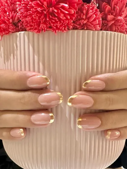 Holding a pop of color to contrast the elegant gold chrome French manicure. This look is a timeless favorite.