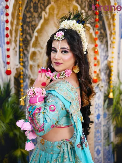A side profile that shows the beautiful hairstyle, adorned with fresh flowers and peacock feathers.