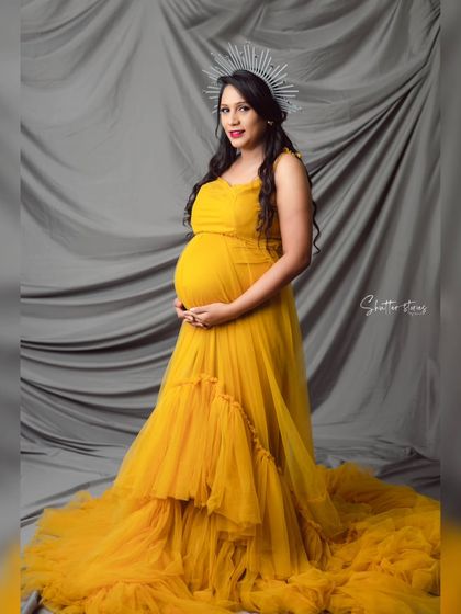 A ray of sunshine in our studio. This mom-to-be is radiant in a flowing yellow tulle gown, complete with a celestial crown for an ethereal touch.