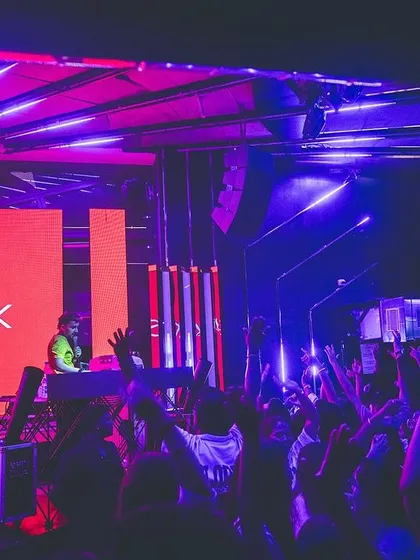 The stage setup at Flo, with vibrant orange and purple lights. The visual production is just as important as the audio for the full Monkstyle experience.