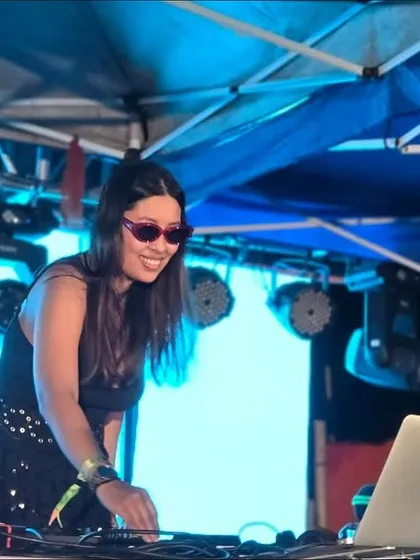 In my element, mixing tracks under the bright lights of an outdoor festival stage. This is a glimpse of my setup and focus during a high-tempo set, ensuring a seamless flow of music for the party.