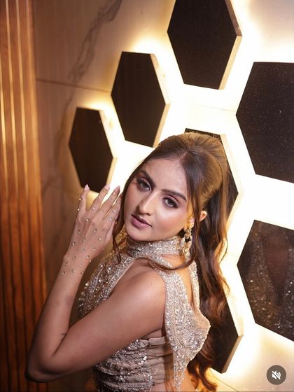 The high ponytail and modern background complement the chic and stylish vibe of this rental gown.