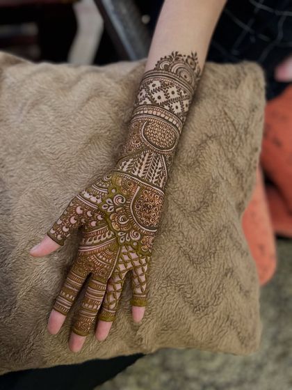 A single arm showcasing a detailed Indian design with beautiful bands and fillers covering the forearm.
