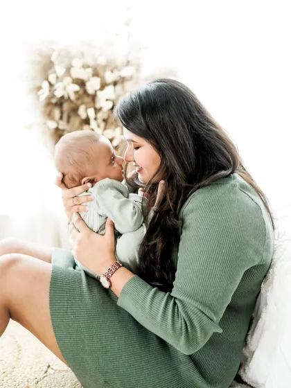 The special bond between a mother and her newborn. This bright, airy portrait captures a moment of quiet connection and adoration in our natural light studio.