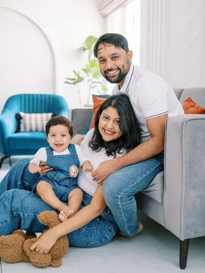 A classic family portrait on the floor, with everyone smiling at the camera. A perfect memory of their son's first year.