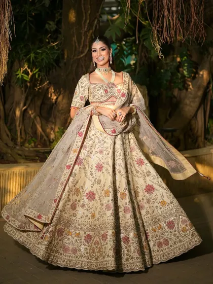 A twirling shot that captures the beautiful movement and intricate floral details of the ivory lehenga. The makeup is kept soft and glowing to complement the outfit.