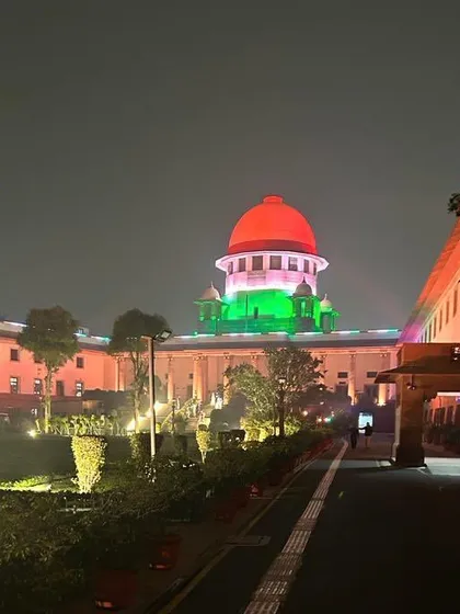 The Supreme Court of India illuminated in the colors of the national flag at night, a symbol of its supreme and infallible role in our democracy.